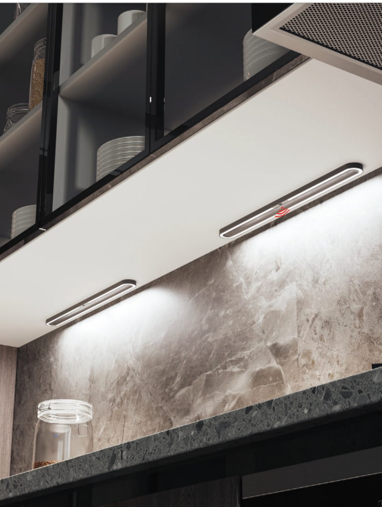 Two linear fixtures mounted under a wall cabinet, lighting a stone splashback